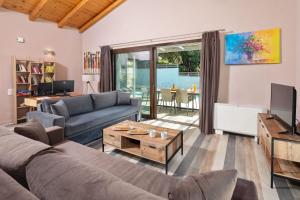 ein Wohnzimmer mit Sofa und Tisch in der Unterkunft Corfu Travel Stories Villa, Private Pool - Stunning Sea Views - Accessible - 4 Bedrooms in Áno Pavliána