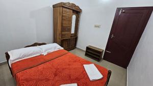 a small bedroom with a bed and a dresser at Tea Mitra Holiday Homes in Vagamon