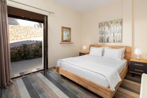 ein Schlafzimmer mit einem Bett und einer Glasschiebetür in der Unterkunft Corfu Travel Stories Villa, Private Pool - Stunning Sea Views - Accessible - 4 Bedrooms in Áno Pavliána + 90 Fotos