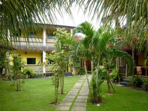 a courtyard with palm trees in front of a building at Flat Bang-Lu in Barra Grande