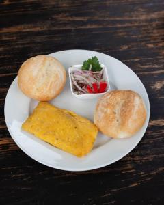 um prato branco de comida com pão e uma sanduíche em Hospedajes & Cabañas Tunki Lodge em Oxapampa