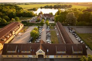 an aerial view of a building with cars parked in a parking lot at Hotel Sørup Herregaard in Ringsted