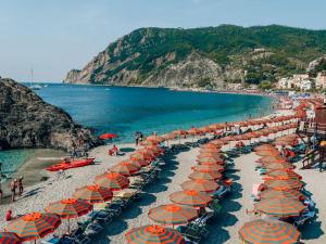 ein Strand mit Sonnenschirmen und Menschen am Strand in der Unterkunft La Casa di Geo Stazione Centrale La Spezia 5 Terre in La Spezia