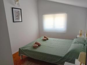 a bedroom with a green bed with two towels on it at Voula's maisonette in Acharavi