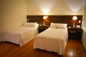 Habitación de hotel con 2 camas y 2 lámparas en Hotel Casino Catamarca en San Fernando del Valle de Catamarca