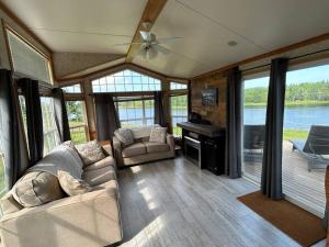 a living room with a couch and a piano at Private Waterfront Getaway in Richibucto