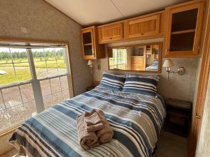 a bedroom with a bed with towels on it at Private Waterfront Getaway in Richibucto