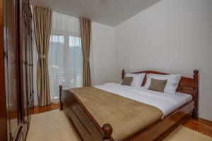 a bedroom with a bed and a large window at Soul of the Kotor Bay in Dobrota