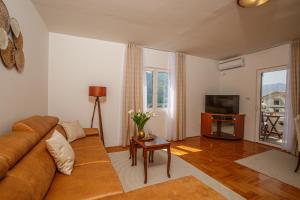 a living room with a couch and a tv at Soul of the Kotor Bay in Dobrota