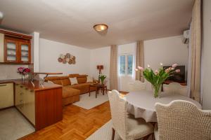 a living room with a table with a vase of flowers on it at Soul of the Kotor Bay in Dobrota