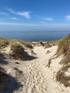 un chemin de sable menant à l'océan sur une plage dans l'établissement DAS LORNSEN - Serviced Luxury Apartments, à Westerland