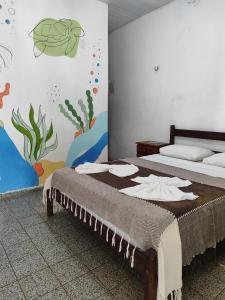 ピパにあるPousada Carambolaのベッドルーム1室(壁に絵画が描かれたベッド1台付)