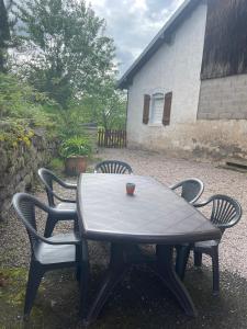 una mesa con sillas y una taza encima en Maison vosgienne 2 à 8 personnes en Rochesson