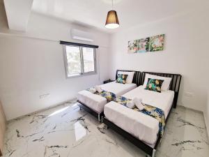 Postel nebo postele na pokoji v ubytování Parrots Paradise 100m From Finikoudes Beachfront