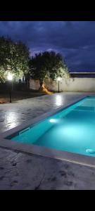 una piscina notturna con acqua blu di B&B L'Uliveto a Marzamemi