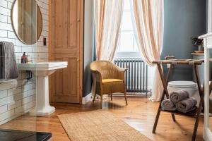 a bathroom with a sink and a chair and a mirror at Luxury Georgian Townhouse in heart of Norwich Sleeps 4 in Norwich
