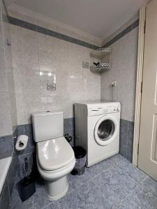 a bathroom with a toilet and a washing machine at Ήσυχο διαμέρισμα στην Ελευσίνα in Elefsina