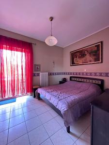 a bedroom with a bed and a red curtain at Ήσυχο διαμέρισμα στην Ελευσίνα in Elefsina