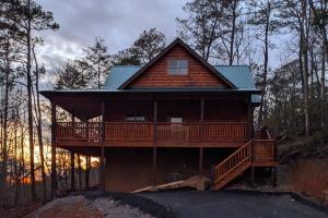 a log cabin with a deck in the woods at Baby Bear Den in Gatlinburg