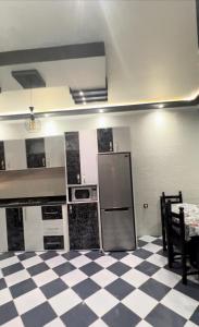 a kitchen with a refrigerator and a checkered floor at Villa Malalien in Tetouan