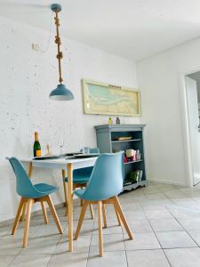 a dining room with a table and two blue chairs at Möwenblick in Wendtorf