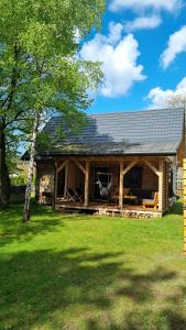 uma cabana de madeira com um telhado de gambrel em Sosnowy Plan em Józefów