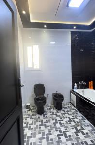 La salle de bains est pourvue de toilettes noires et d'une baignoire. dans l'établissement Villa Malalien, à Tetouan
