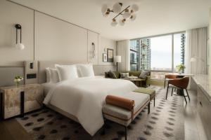 a bedroom with a large white bed and a living room at Four Seasons Hotel Toronto at Yorkville in Toronto