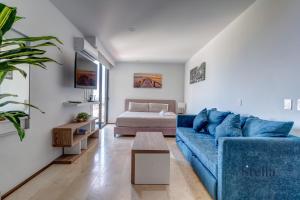 a living room with a blue couch and a bed at A Perfect Place in Playa del Carmen