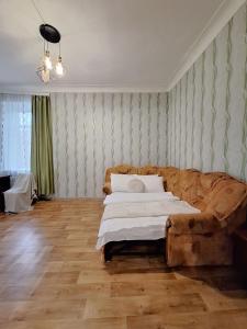 ein Wohnzimmer mit einem Bett und einem Sofa in der Unterkunft Березовий сквер Апартаменти біля Обласної лікарні і госпіталю Документи для відряджень in Poltawa