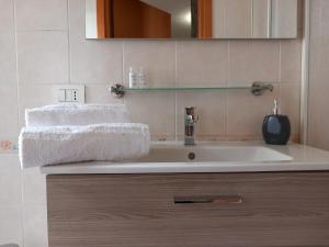 a bathroom with a white sink and a mirror at BAARIA PORTO rooms in Milazzo