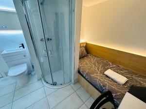 a small bathroom with a shower and a bed at Not Very Quiet But Best Location in London
