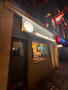 een winkel voor een super sandwich winkel 's nachts bij Not Very Quiet But Best Location in Londen
