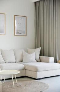 un soggiorno con un divano bianco e un tavolo di Rewal -2 Bedroom- Premium Baltic Apartment with SPA access a Rewal