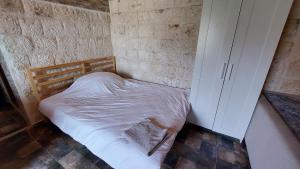 a small bedroom with a bed and a cabinet at Kekova Hassan's Pansiyon in Demre