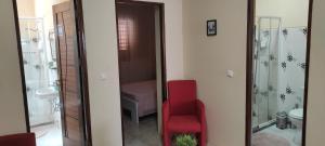bagno con sedia rossa e doccia di guesthouse emaly a Mindelo