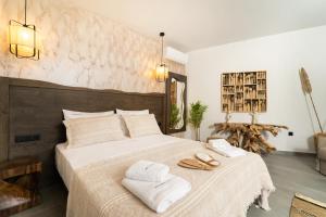 a bedroom with a large bed with towels on it at Stone Village Skala Maries in Skala Marion