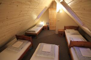 um quarto com 4 camas num sótão em Chata nad stawem em Wierchomla Mała