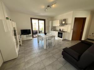 una cucina e un soggiorno con un tavolo e un divano di Gris I Blanca apartment ad Alghero