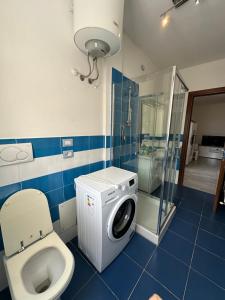 un bagno con lavatrice e WC di Gris I Blanca apartment ad Alghero