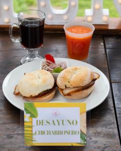 a plate with a sandwich and a drink on a table at Hospedajes & Cabañas Tunki Lodge in Oxapampa