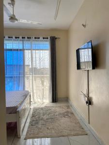a living room with a large window and a television at Graceful Listing in Mombasa