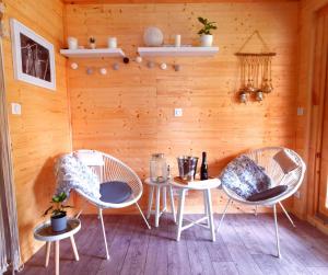 una habitación con 3 sillas y una mesa con una botella de vino en "L Eden enchanté" Chambres d'hôtes et SPA Côté Basque, en Boucau