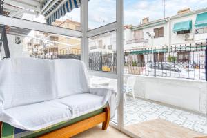 a balcony with a white chair and a window at Sunflower Patagonia in Santa Pola