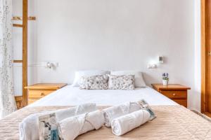 una camera da letto con un grande letto bianco con cuscini di Sunflower Patagonia a Santa Pola
