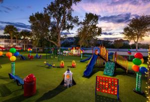 a playground in a park with a lot of playground equipment at Magic Moment Resort & Kids Club, Dazzler Select by Wyndham in Kissimmee