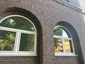 two windows on the side of a brick building at Casa Luna 6 min Hbf , Erdgeschosswohnung ,Altbau in Duisburg