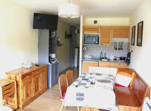 a kitchen with a table and a dining room at Studio cosy avec terrasse au cœur du village in Xonrupt-Longemer