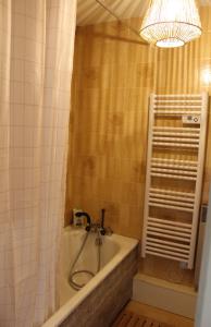a bathroom with a bath tub and a chandelier at Studio cosy avec terrasse au cœur du village in Xonrupt-Longemer