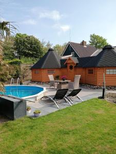 a backyard with a log cabin and a swimming pool at Kota Wadway in Spanbroek